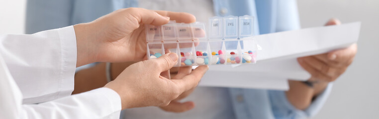 Doctor holding box with pills for senior woman, closeup