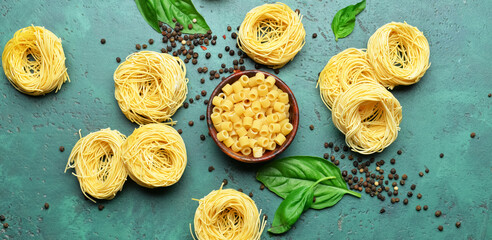 Composition with uncooked pasta, basil and spices on green background - Powered by Adobe