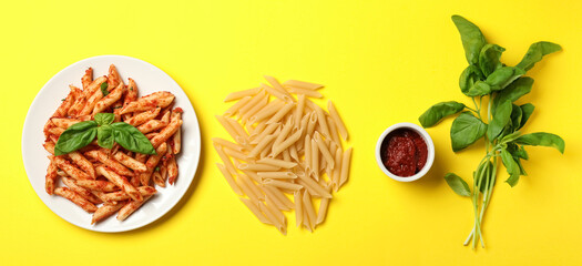 Tasty pasta, tomato sauce and basil on yellow background