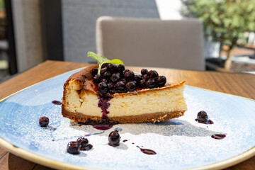 Blueberry cheesecake on the blue plate in the restaurant