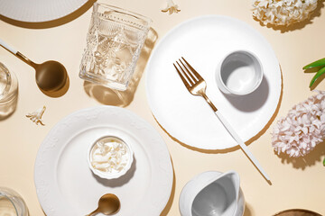 Composition with clean dishes, cutlery and hyacinth flowers on beige background