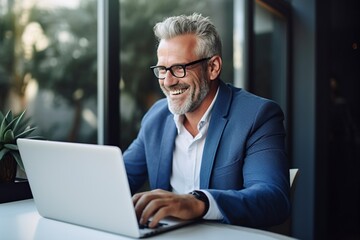happy mature businessman executive manager looking at laptop