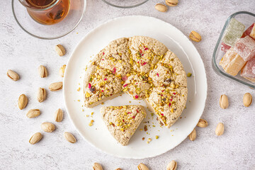 Plate of tasty Tahini halva with pistachios on light background
