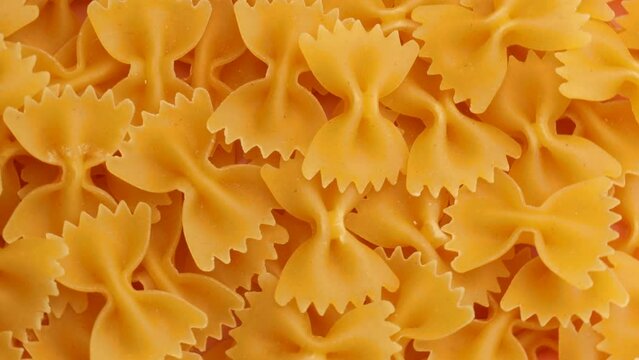 dry pasta farfalle, rotation in circle. Turning pasta background. selective focus