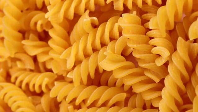  dry pasta fusilli , rotation in circle. dry spirals Turning. selective focus. vertical video
