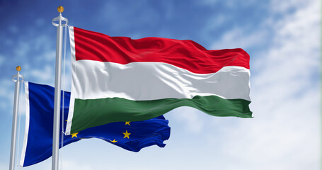 The flags of Hungary and the European Union fluttering together on a clear day