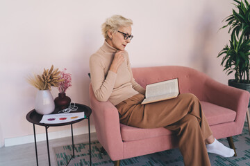 Mature woman reading book in armchair
