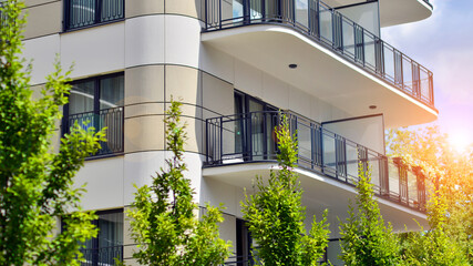 Fototapeta na wymiar Modern residential building with new apartments in a green residential area. Eco architecture. Green tree and new apartment building. The harmony of nature and modernity.