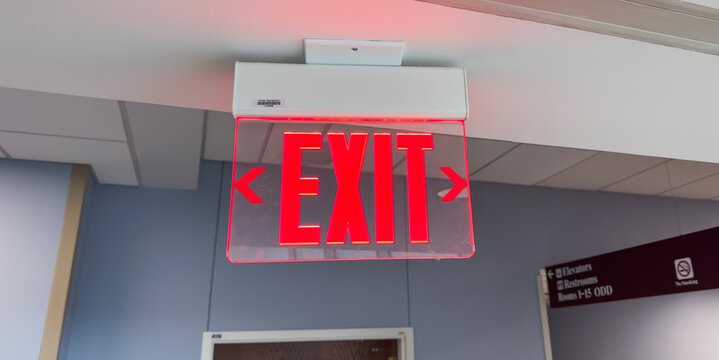 red exit sign above the door, a symbol of safety, escape, and a way out in emergencies. Represents hope and assurance in uncertain situations. Concept of finding an exit