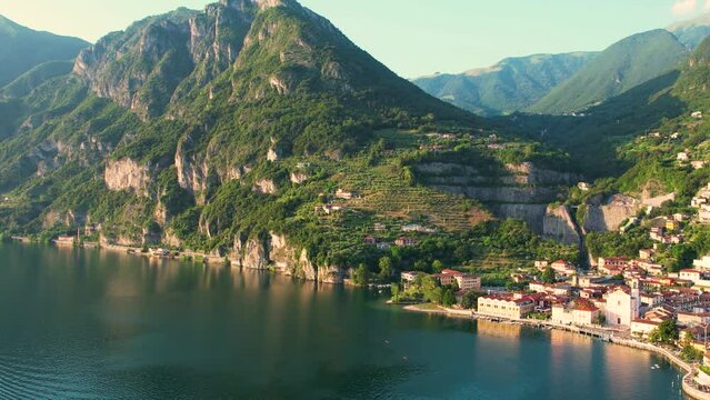 Aerial 4K footage of Marone, Lake Iseo. Aerial panoramic sunset view of Marone town surrounded by mountains and located in Iseo Lake, Brescia, Lombardy, Italy