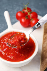Bowl with tasty tomato sauce on table, closeup