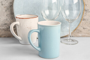 Set of different dishes on table near grey grunge wall