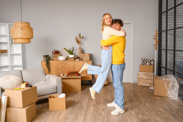 Fototapeta na wymiar Young couple hugging in room on moving day