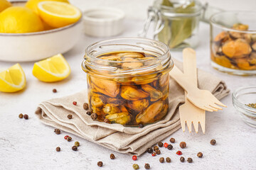 Jar with pickled mussels on white background