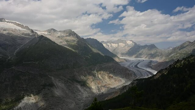 Landscape of glacier, mountain and forest. Time lapse of Aletsch Glacier in Swiss Alps. Riederalp, Valais Canton, Switzerland. Travel destinations. Ice melting.