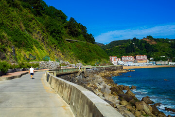 Naklejka premium Concrete walking trail along the Atlantic Ocean and mountains, Way of St James, Basque Country, Spain