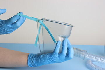 Health care professional wearing gloves holding the oxygen mask 