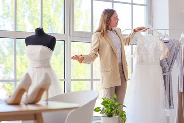 Female wedding planner with dress in office