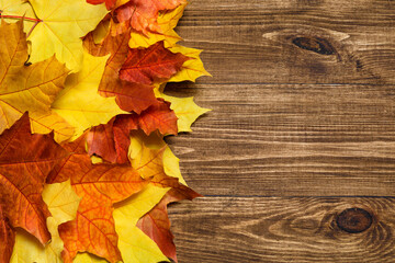 Naklejka na ściany i meble Autumn mood composition background. Frame made of autumn dried leaves on wooden background. Colorful, variegated foliage. Flat lay, top view, copy space.