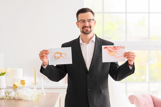 Male wedding planner with pictures of rings in office