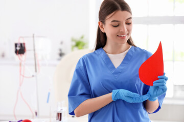 Female nurse with paper blood drop in clinic
