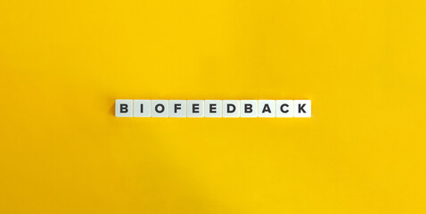 Biofeedback Word on Block Letter Tiles on Yellow Background. Minimal Aesthetic.