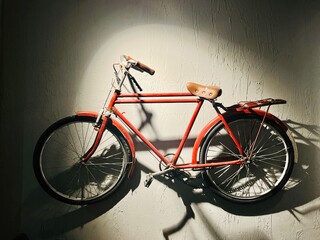 Fototapeta na wymiar Red bicycle hanging on the wall, vintage red bicycle
