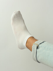 Fototapeta na wymiar white sock with copy space on human foot closeup photo on white background