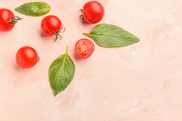 Composition with ripe cherry tomatoes and basil leaves on beige background