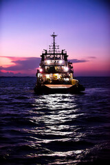 Cargo ship on the sea arriving to the harbor by night
