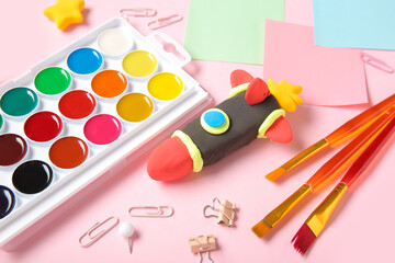 Naklejka premium Rocket made of plasticine with different stationery on pink background