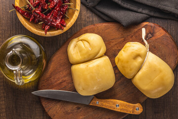 Smoked scamorza cheese on cutting board. Top view.