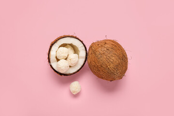 Coconut with white chocolate candies on pink background