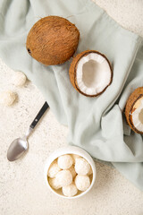Coconuts and bowl with white chocolate candies on light table