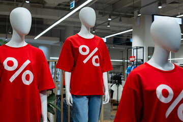 Mannequin in a clothing store in a red t-shirt with a percent sign. Advertising sale and discount...