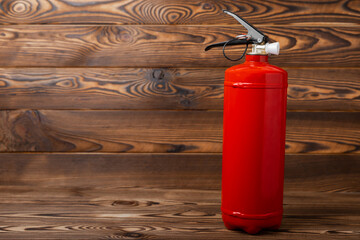 Fototapeta premium Fire extinguisher on brown texture background. Fire protection, home fire extinguisher. home security concept. Place for text. Copy space.banner