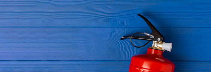 Fire extinguisher on a blue textural background. Fire protection, home fire extinguisher. home security concept. Place for text. Copy space.banner