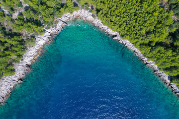 AERIAL: Incredible shape of a bay along rocky coast of sunny island of Hvar