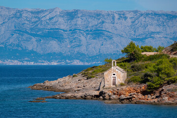 Abandoned old stone chapel on the edge of a small rocky cape on island of Hvar