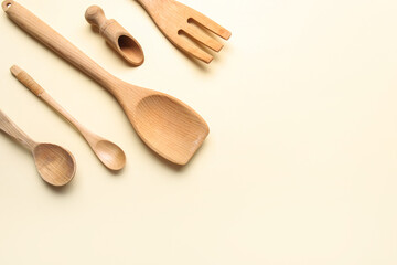 Set of wooden kitchen utensils on color background