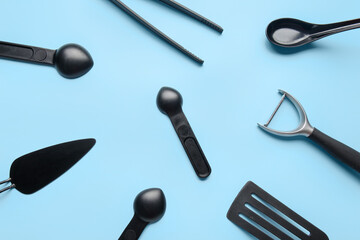 Composition with black kitchen utensils on color background