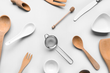Composition with different kitchen utensils on light background