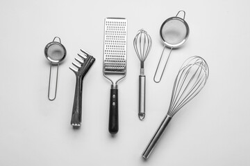 Set of stainless steel kitchen utensils on light background