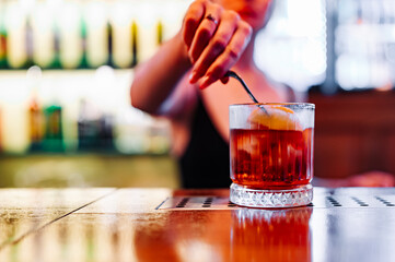 woman hand bartender making negroni cocktail