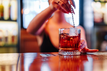 woman hand bartender making negroni cocktail