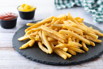 Fried potatoes, french fries on wooden table