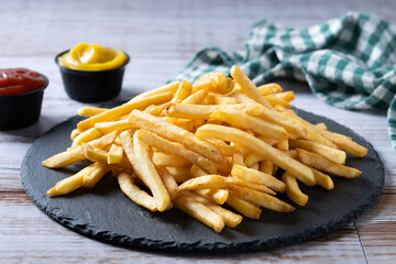 Fried potatoes, french fries on wooden table