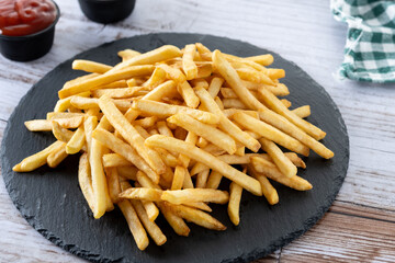 Fried potatoes, french fries on wooden table
