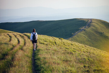 Young Girl with a Backpack Walks Alone in the Ukrainian Carpathian Mountains