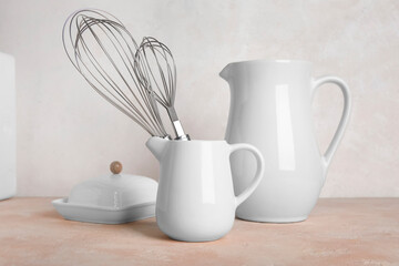 Set of different kitchen utensils on color table against light background